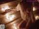 A woman sitting on the steps of a building with lit candles.