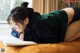 A woman laying on a bed reading a book.