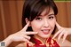 A woman in a red cheongsam posing for a picture.