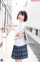 A woman in a school uniform is posing for a picture.