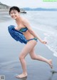 A woman in a bikini running on the beach.